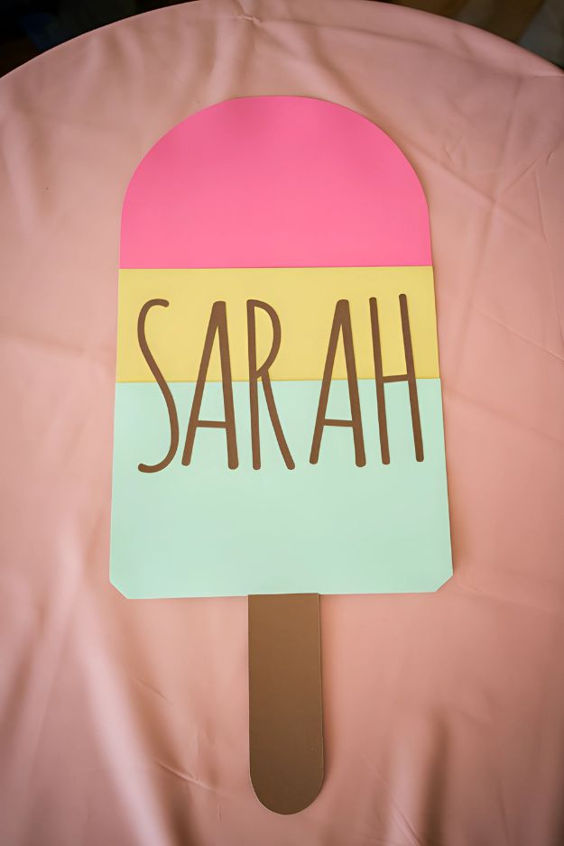 Large paper popsicle craft with pink, yellow, and mint layers and the name “Sarah” written across