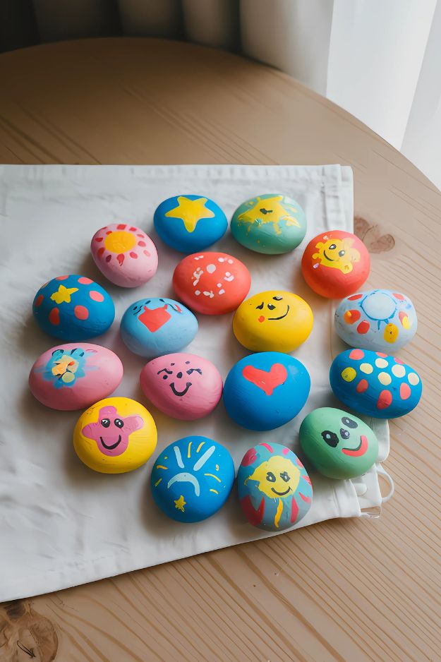 Summer crafts for kids of brightly painted rocks with summer-themed faces, symbols, and colors.