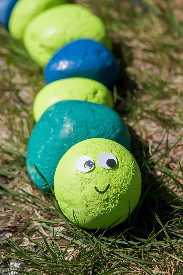 Summer crafts for kids of Painted rock caterpillar with googly eyes and a smiling face on the front rock.