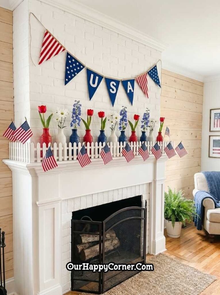 4th of July fireplace mantel featuring a white picket fence along the shelf