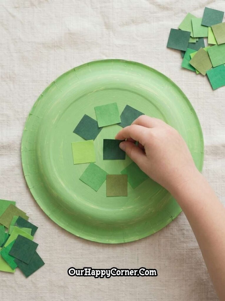 child placing green paper squares onto plate
