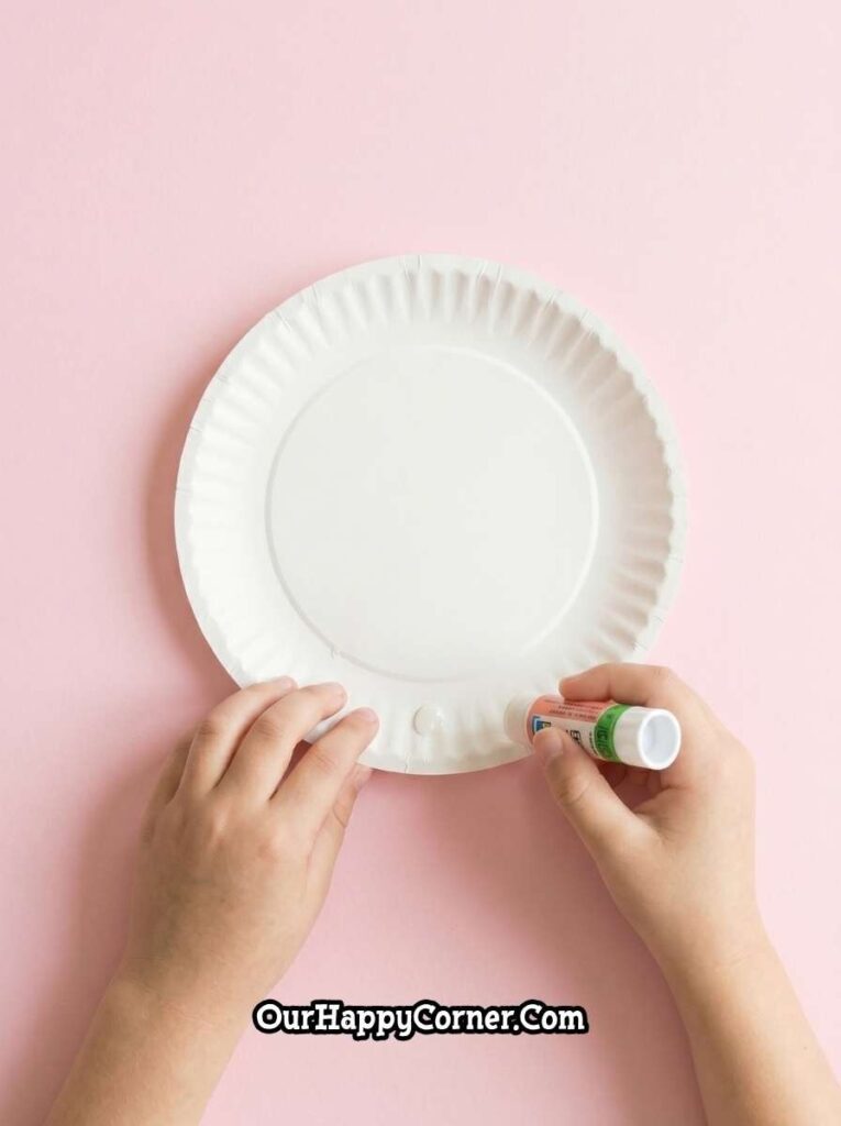 Gluing paper cone onto paper plate to create a base 
