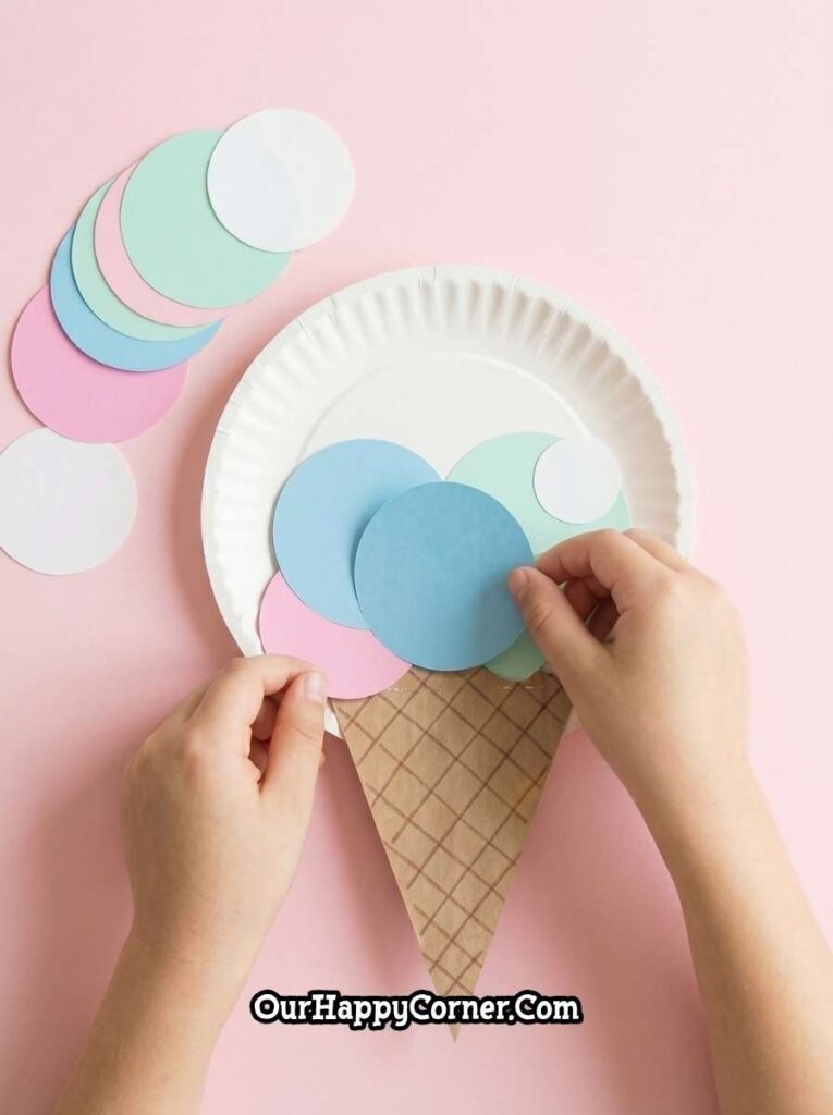 Layering colorful paper circles onto plate to form ice cream scoops
