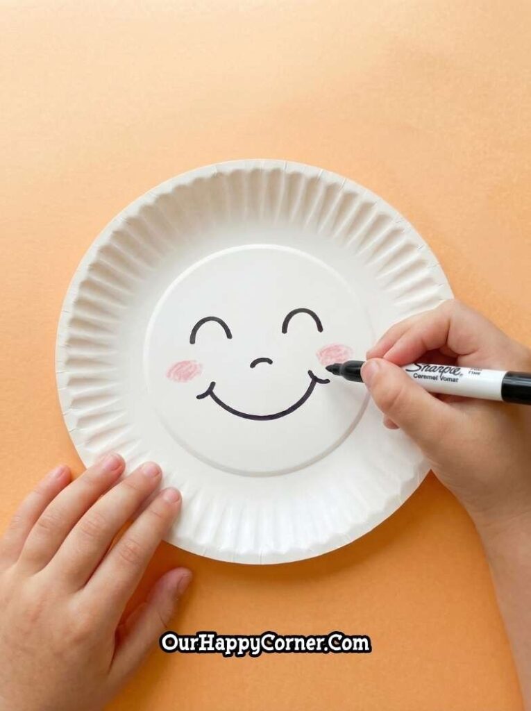 Smiley face drawn of paper plate