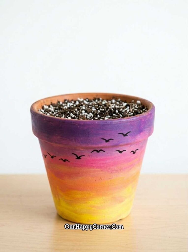 Sunset ombre terracotta pot painting with bird silhouettes yellow to purple