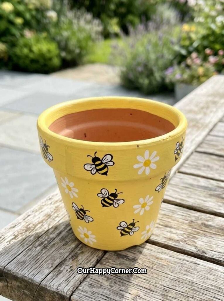 Yellow terracotta pot painting with bumblebees and white daisies garden bench