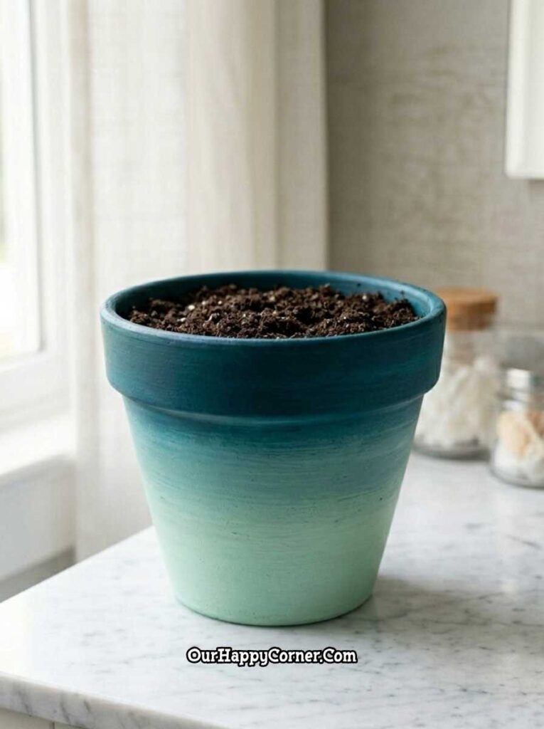 Teal ombre painted terracotta pot on white marble kitchen counter