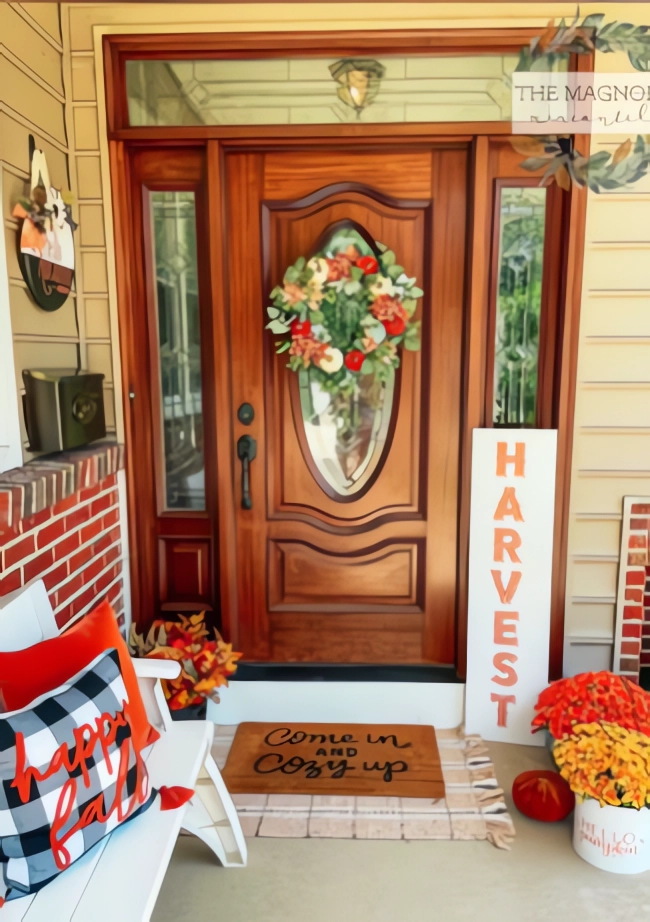Wooden front door with autumn wreath, "HARVEST" sign, and fall-themed decorations