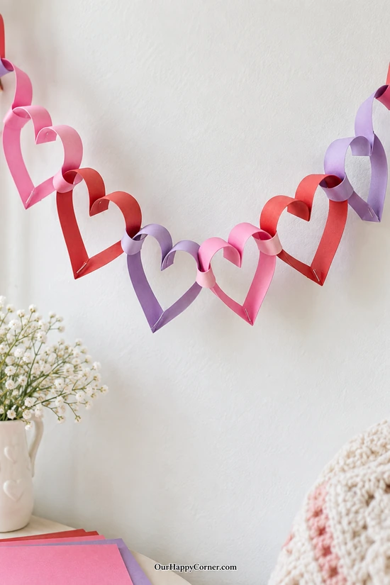 Linked pink red and purple paper heart garland
