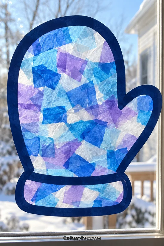 Blue tissue paper mitten suncatcher on a window