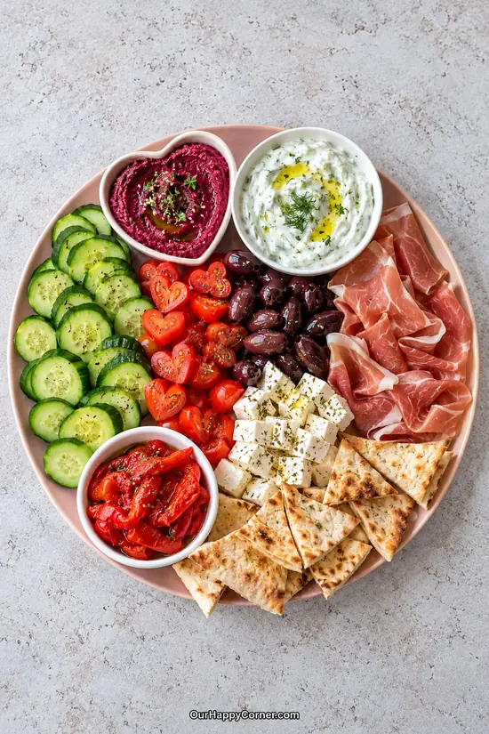 Mediterranean Valentine’s charcuterie board with beet hummus, feta, prosciutto, pita, and vegetables