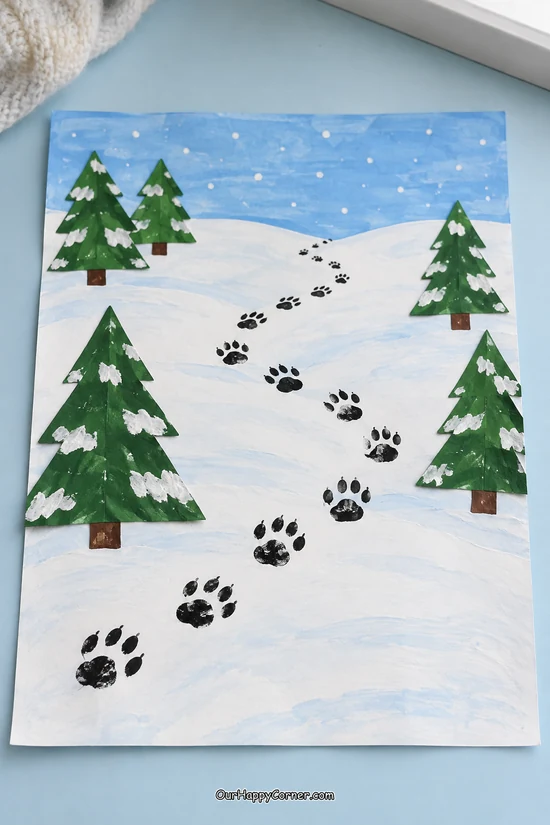 Stamped animal tracks winding through a snowy paper landscape