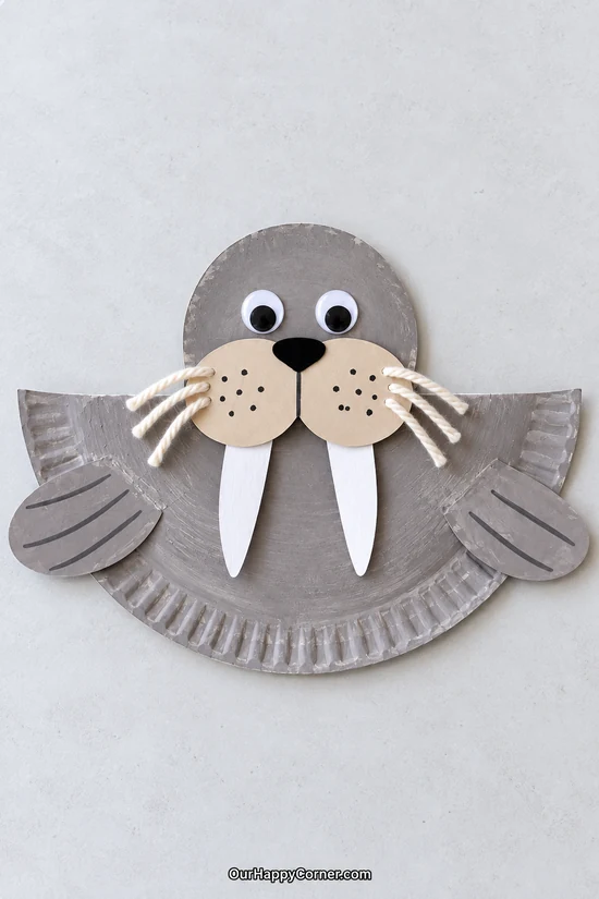 Flat paper plate walrus with glued flippers and yarn whiskers winter crafts for kids