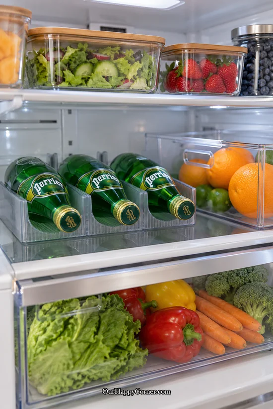 Horizontal sparkling-water bottles supported by refrigerator bottle cradles