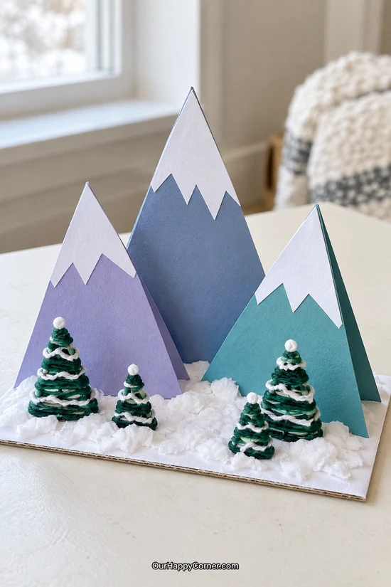 Folded paper snowy mountains with small yarn wrapped trees winter crafts for kids